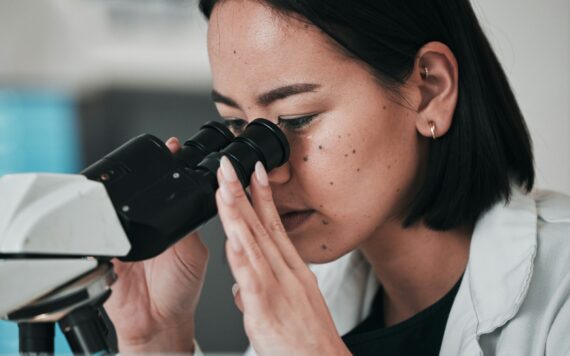 Science, microscope and Asian woman in laboratory for sample, data analysis and study. Biotechnolog